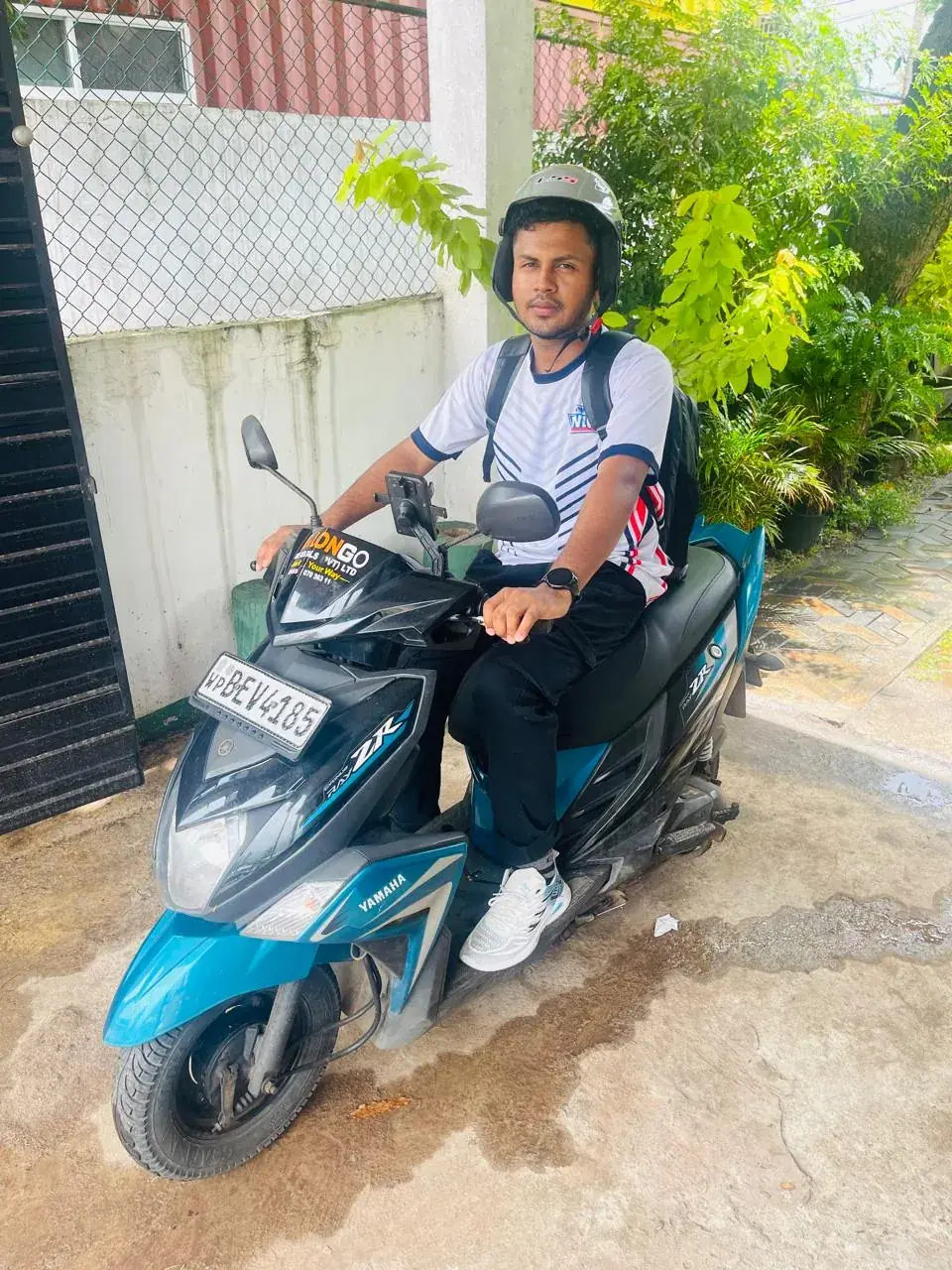 Traveller seated on a teal Yamaha Ray ZR with CeylonGo branding