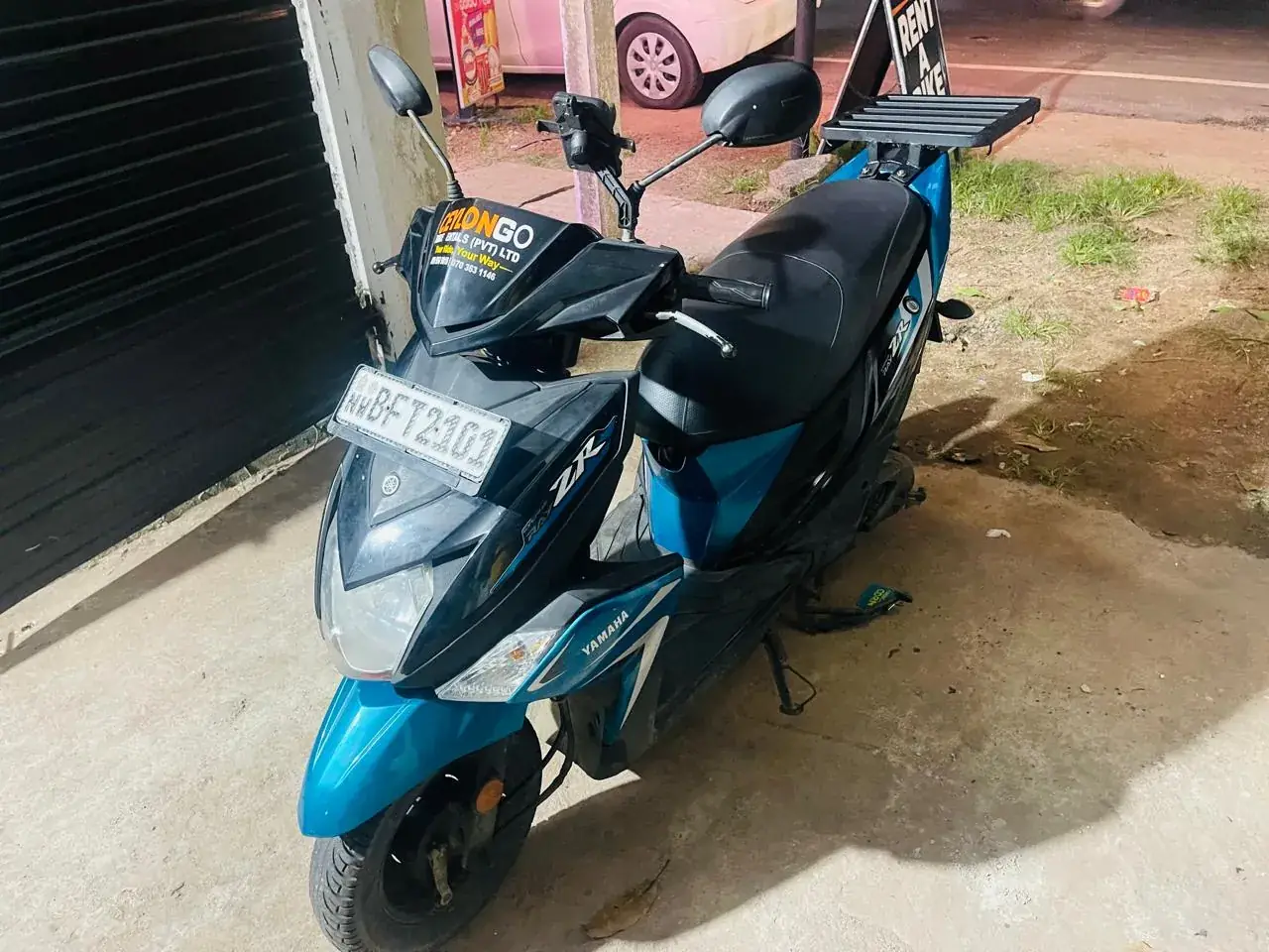 Teal Yamaha Ray ZR with luggage rack parked outside CeylonGo Bike Rentals