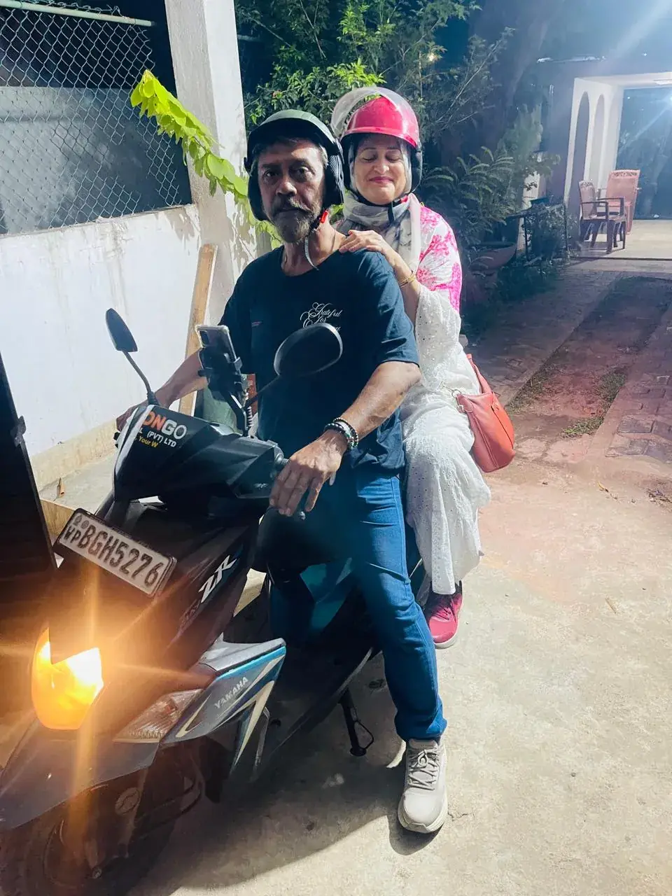 Couple on a CeylonGo scooter at night with the headlight on