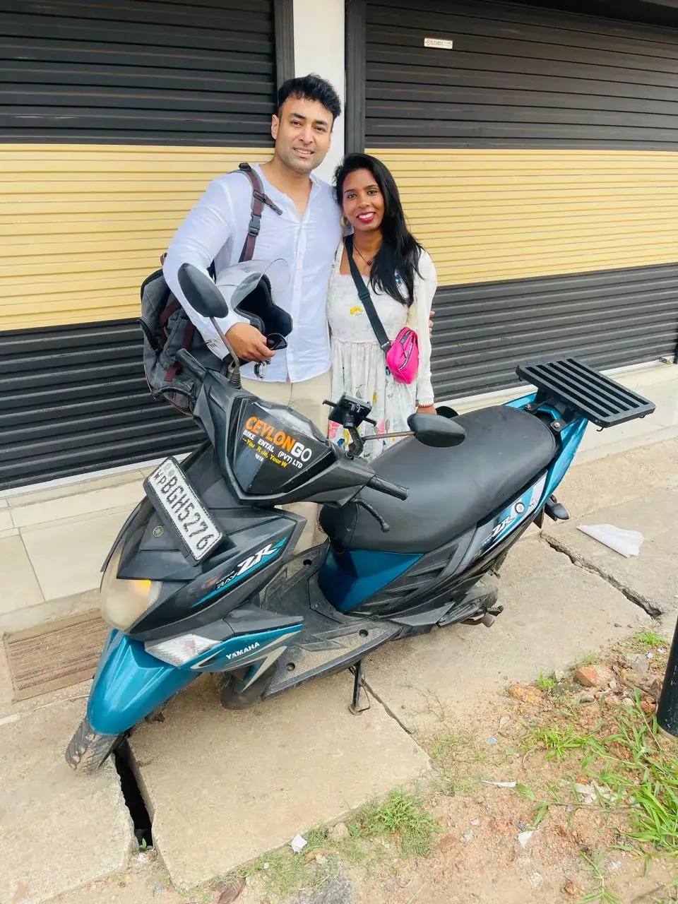 Couple with a CeylonGo Yamaha Ray ZR outside the rental shop