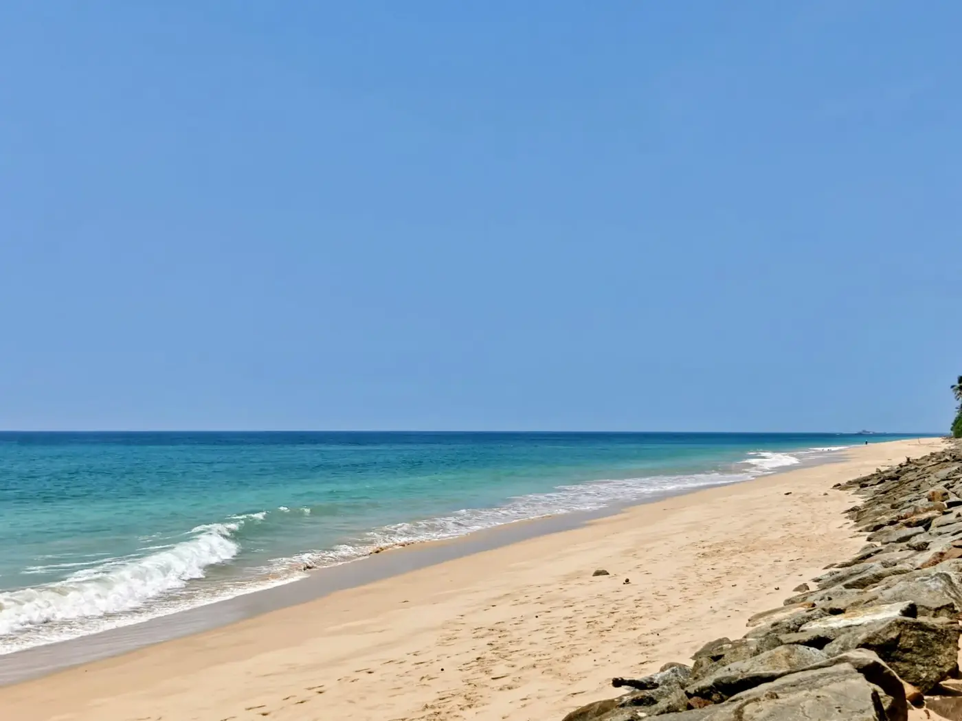Sandy beach in Bentota with gentle waves of the Indian Ocean
